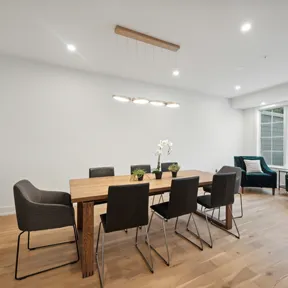 Dining area with dining table and extra seating below windows in Chestnut Hill, PA home