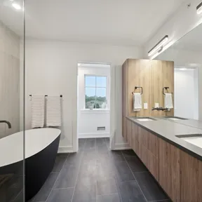 Primary bathroom with matte black tub and double vanity in Chestnut Hill, PA home