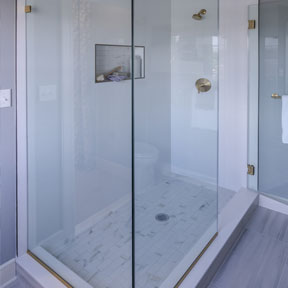 Large glass shower with marble style floors and shower niche in the owner's suit of the Hamilton model.