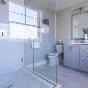 Reserve at Chalfont owner's bathroom featuring large glass shower, vanity with cabinet storage, and wood style tile floor