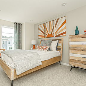 Bedroom of the Jordan model home with bed, window, recessed lighting, and wall to wall carpeting