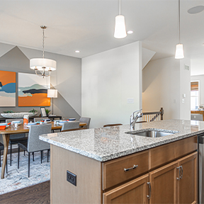 Kitchen island with built in sink at the Jordan model home with views of the dining space