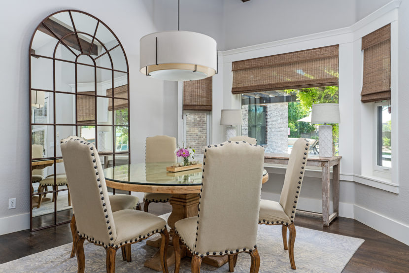 Modern dining room interior design with lots of natural lighting and huge farmhouse mirror.