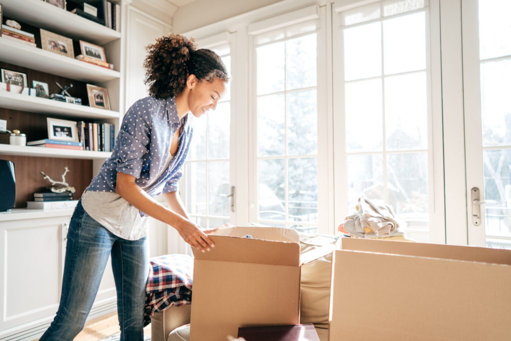 Woman packing up items before donating trying to organize her home.