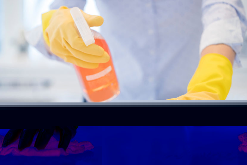 Close Up Of Woman Using Spray Polish To Clean Kitchen Surface
