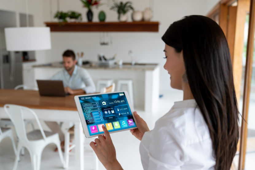 woman setting up the intelligent home system on a tablet computer