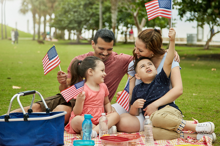 Family having a picnic and waving American flags