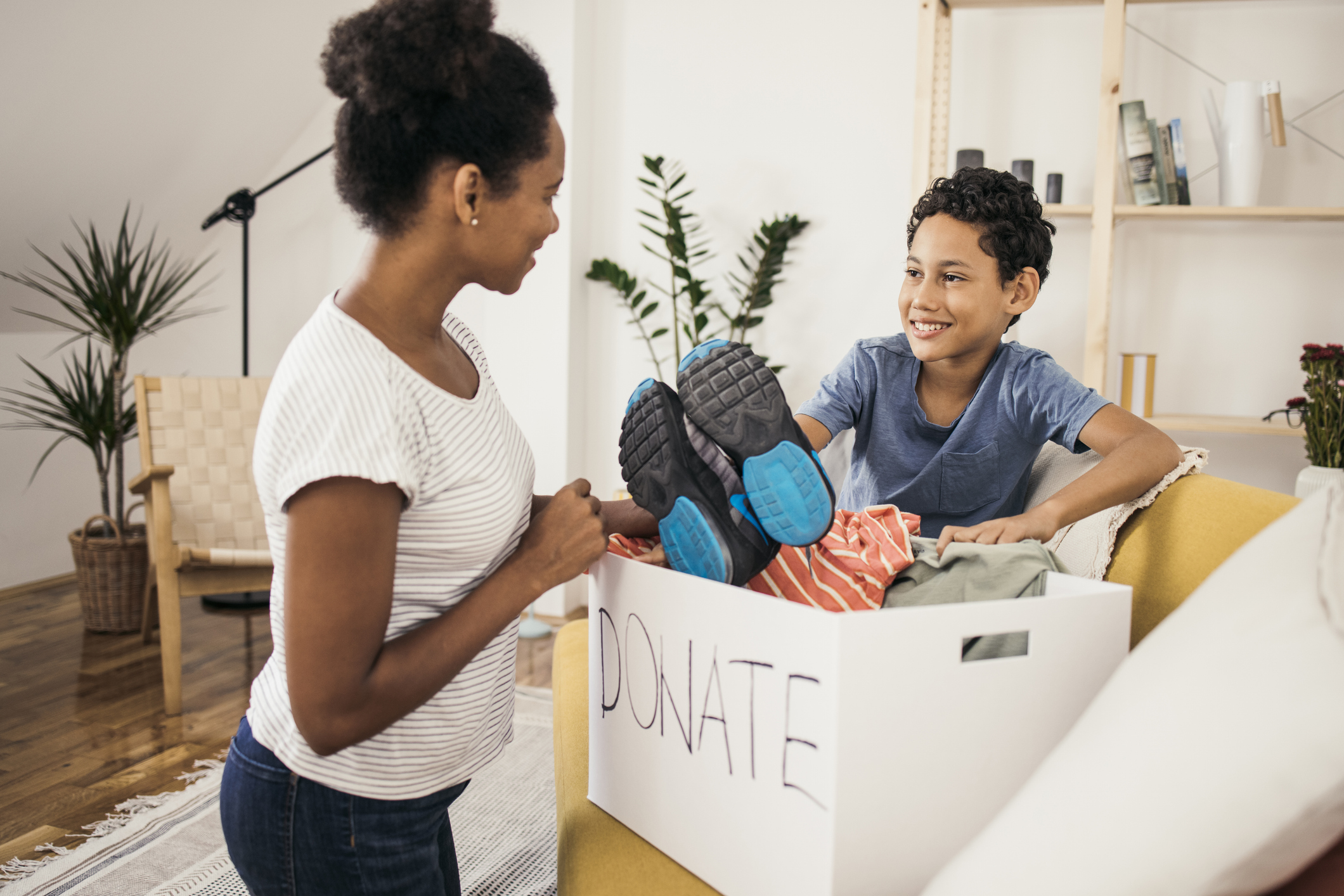 Mother and son preparing a box of clothes for donation