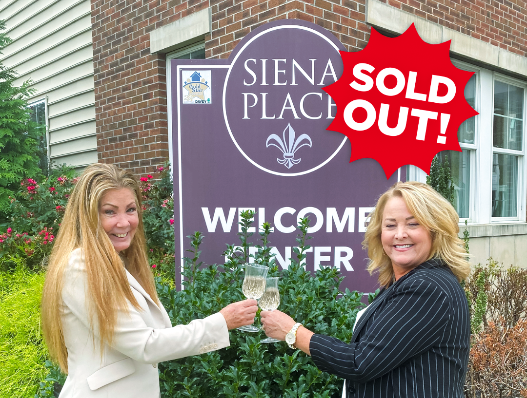 Two women toasting to a sold out Siena Place